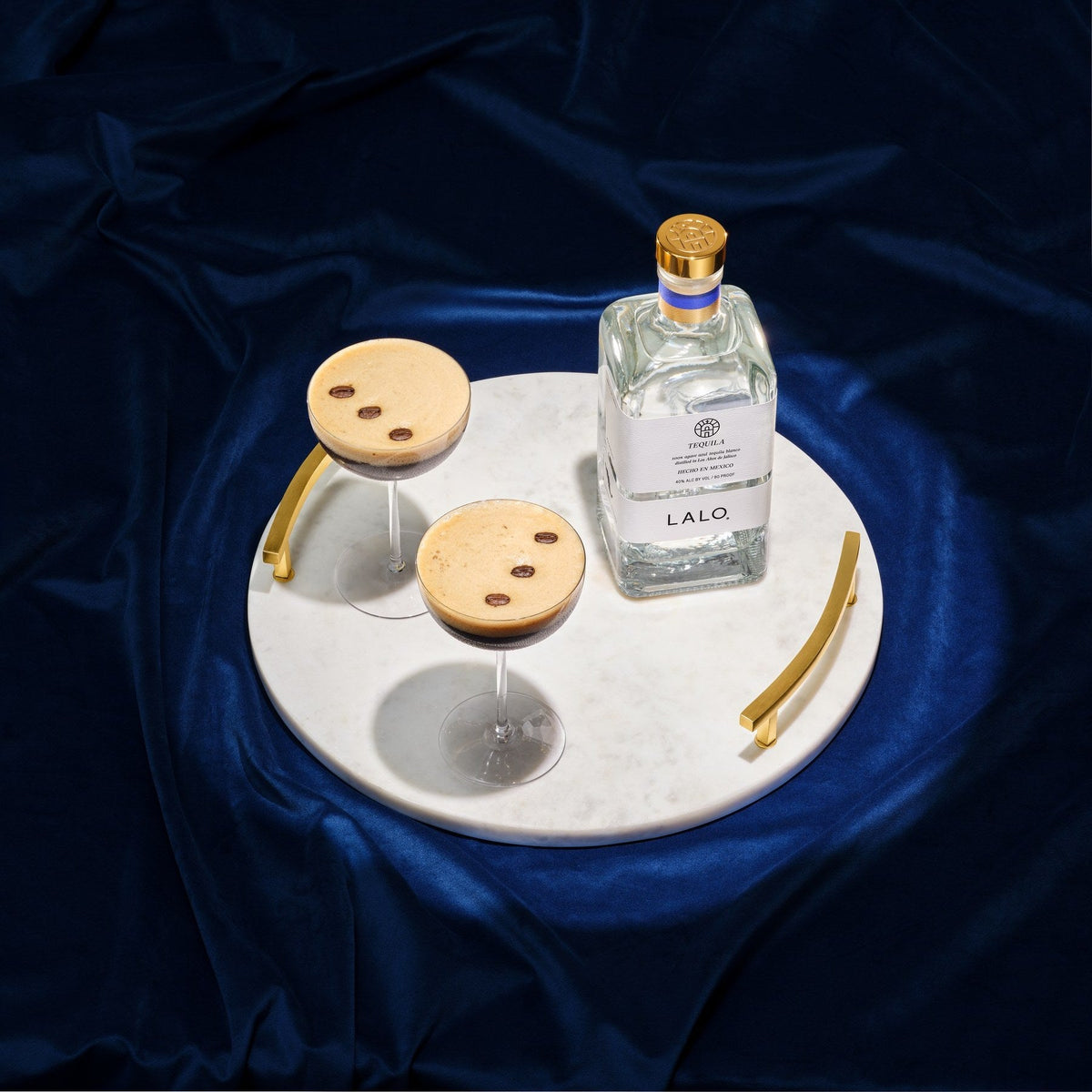 Two espresso martinis and a bottle of LALO Tequila Blanco on a marble tray